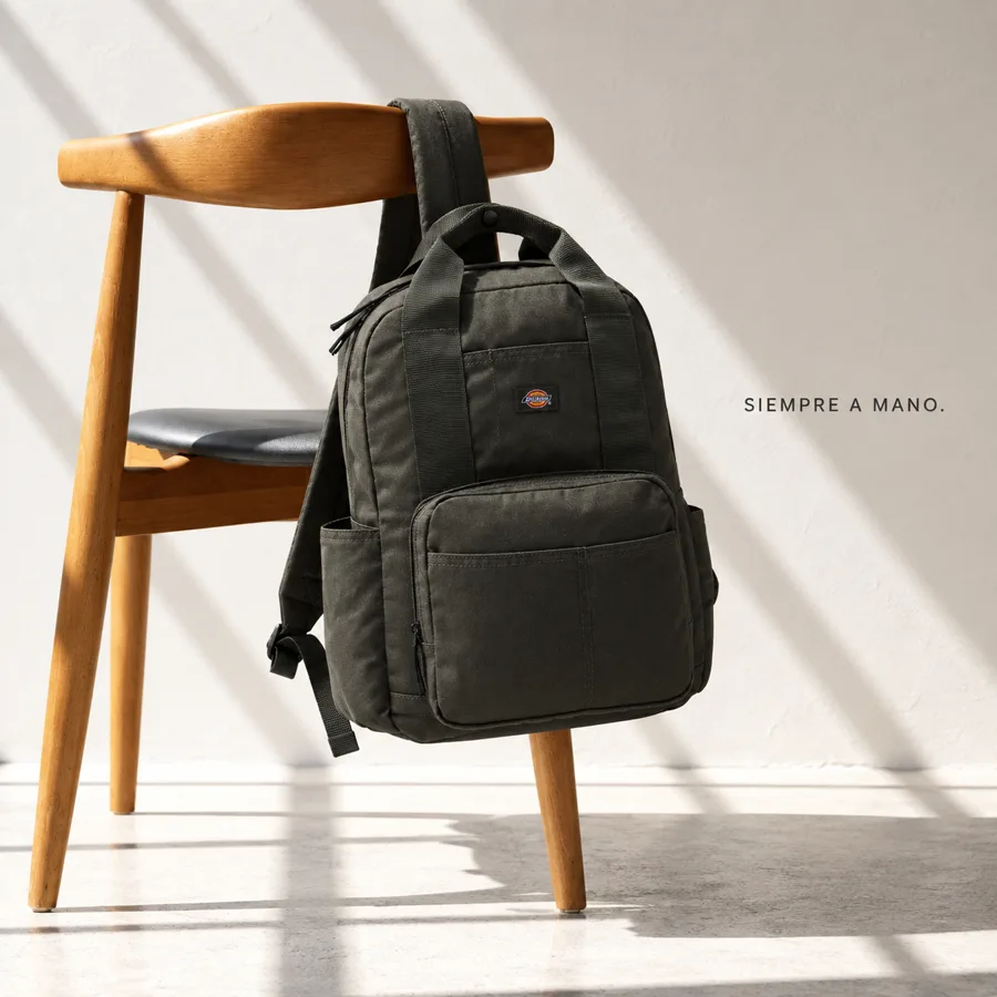 Mochila negra sobre una silla de madera en un ambiente claro con luz natural, demostración generada con IA.